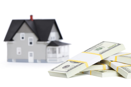 Bundles of dollars in front of house architectural model, isolated